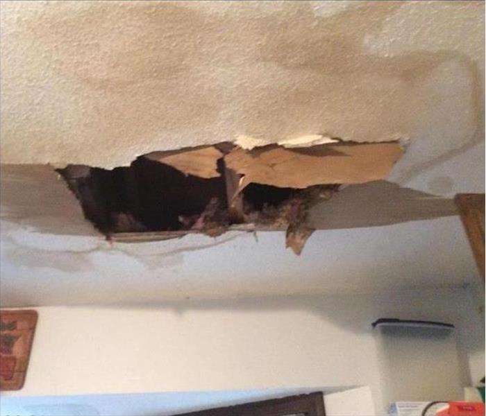 hole in ceiling with water stains around hole