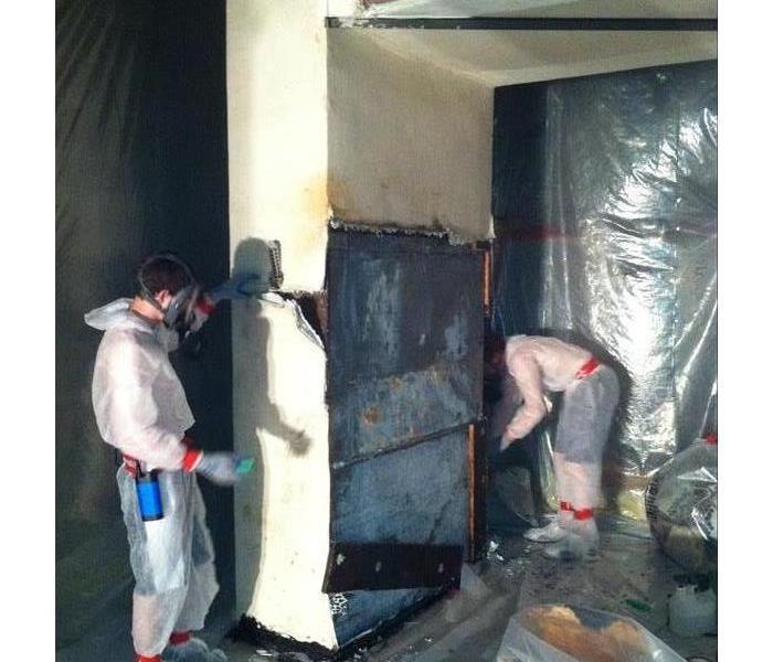 Technicians in safety suits while remediating mold